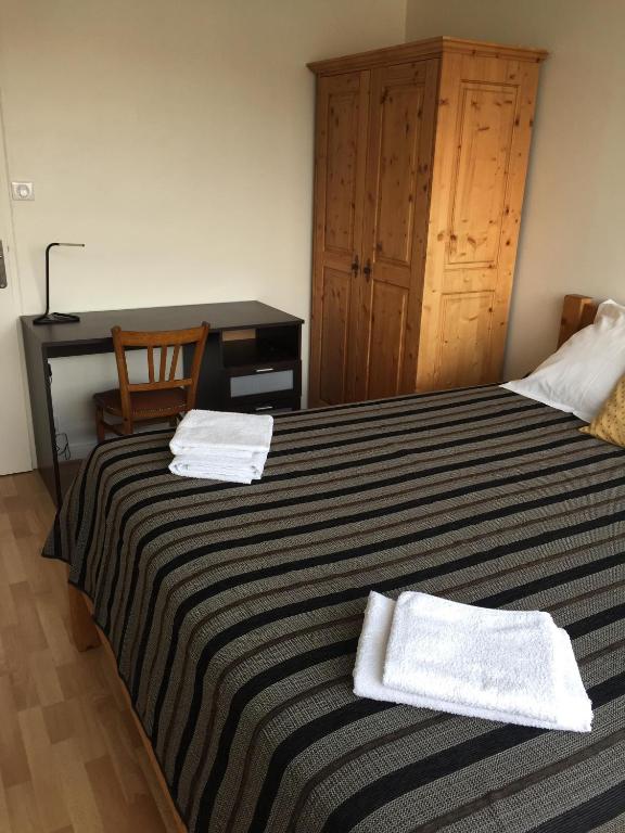 une chambre avec un lit avec deux serviettes dessus dans l'établissement Le Puy de Dôme, à Clermont-Ferrand