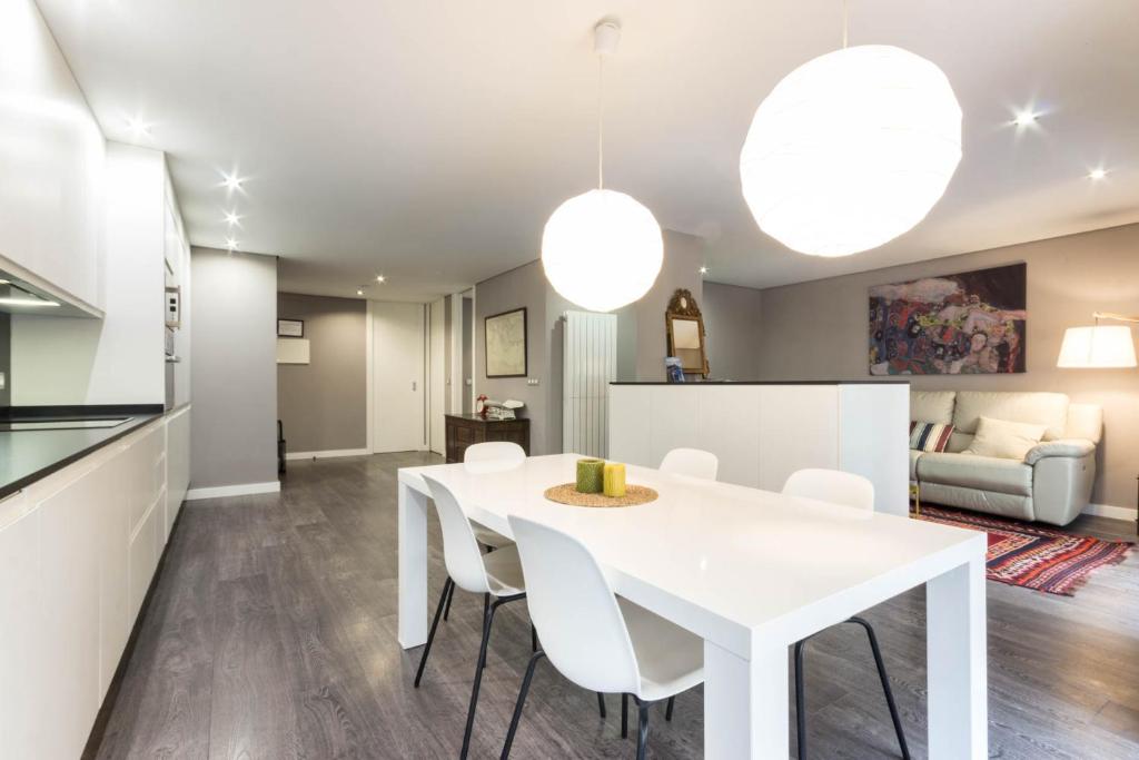 a kitchen and dining room with a white table and chairs at POZAS by Kyosai in Bilbao