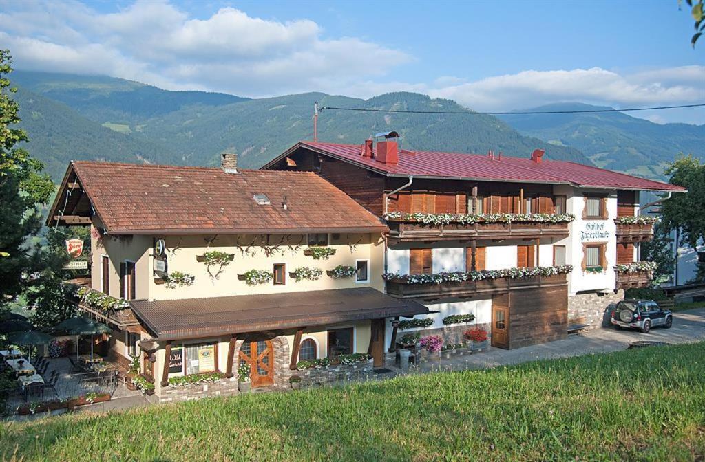 a house on a hill with mountains in the background at Gasthof Jägerklause in Stummerberg