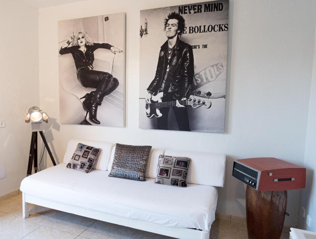 a living room with a white couch and posters on the wall at Pikes Ibiza in San Antonio