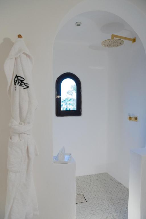 a bathroom with a white wall with a window at Pikes Ibiza in San Antonio
