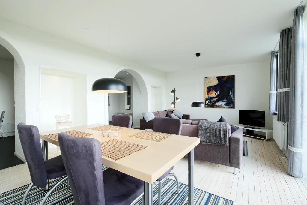 Allerup Gamle Skole (005) في Tjæreborg: غرفة طعام وغرفة معيشة مع طاولة وكراسي