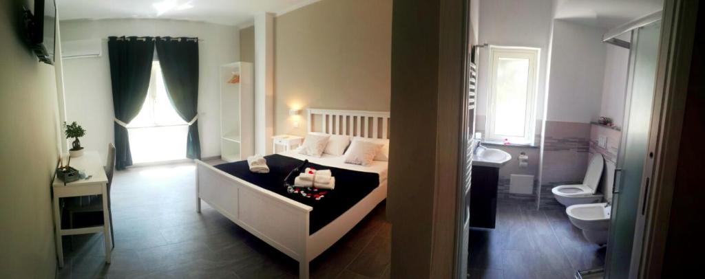 Cosmo Rooms a pochi passi da Tropea في سانتا دومينيكا: غرفة نوم بسرير ومغسلة ومرحاض