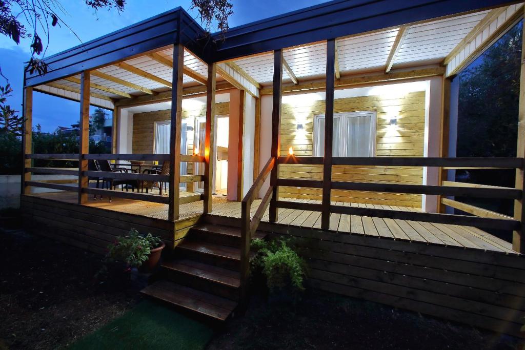 a modular home with a deck and a pergola at Mobile homes Olive and Sea in Bibinje