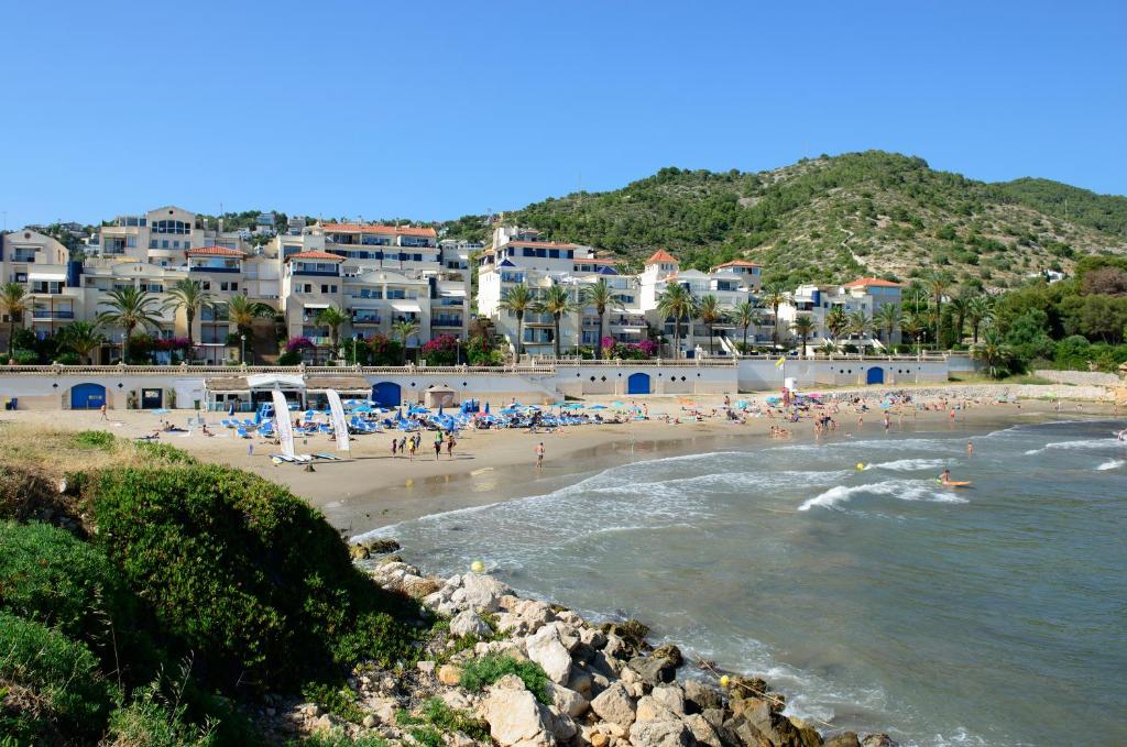 uma praia com um monte de pessoas na água em Sitges Aiguadolç playa em Sitges