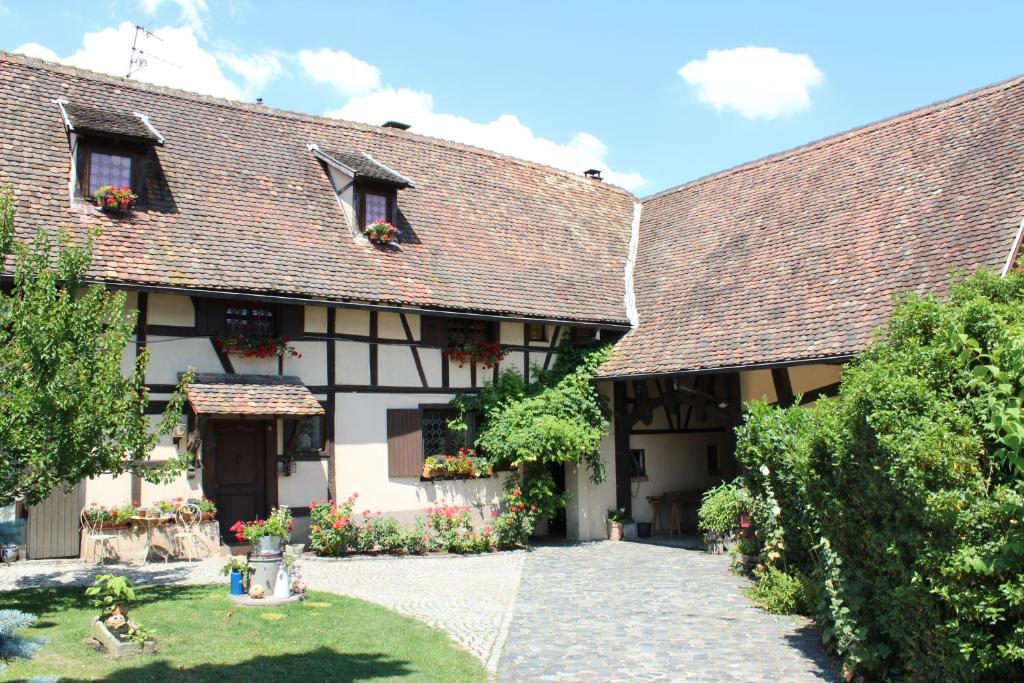 un vecchio edificio con fiori nel cortile di B&B La Tête dans les Etoiles a Weyersheim