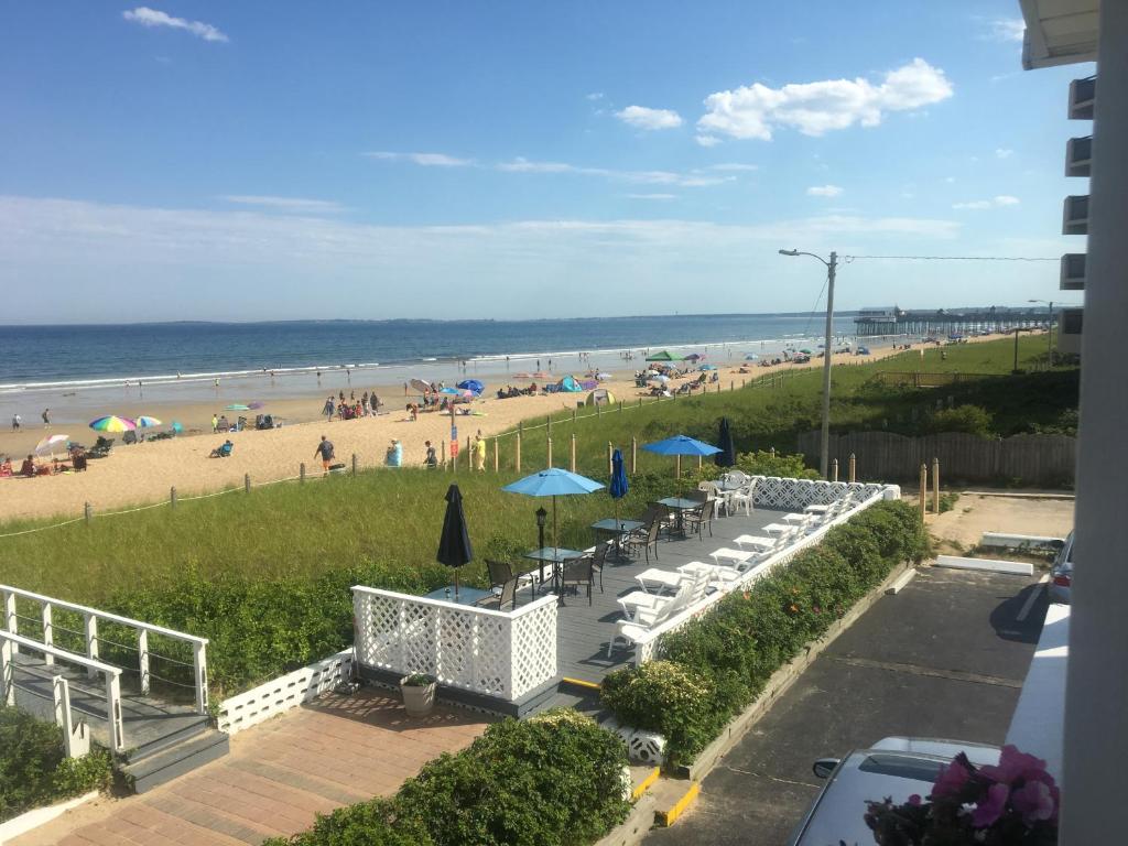 uma vista para uma praia com cadeiras e guarda-sóis em Sandpiper Beachfront Motel em Old Orchard Beach