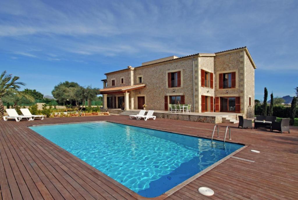 a villa with a swimming pool in front of a house at Santa Maria in Alcudia