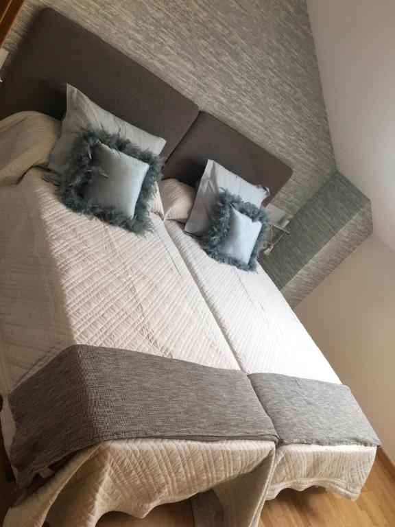 a bedroom with a large bed with pillows at Ático Jaca Ciudadela in Jaca