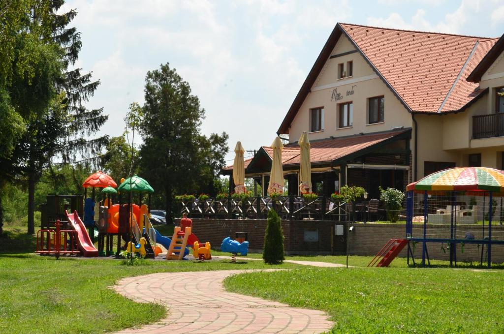 um parque com parque infantil com escorregas e guarda-sóis em Hotel Moja Čarda em Temerin
