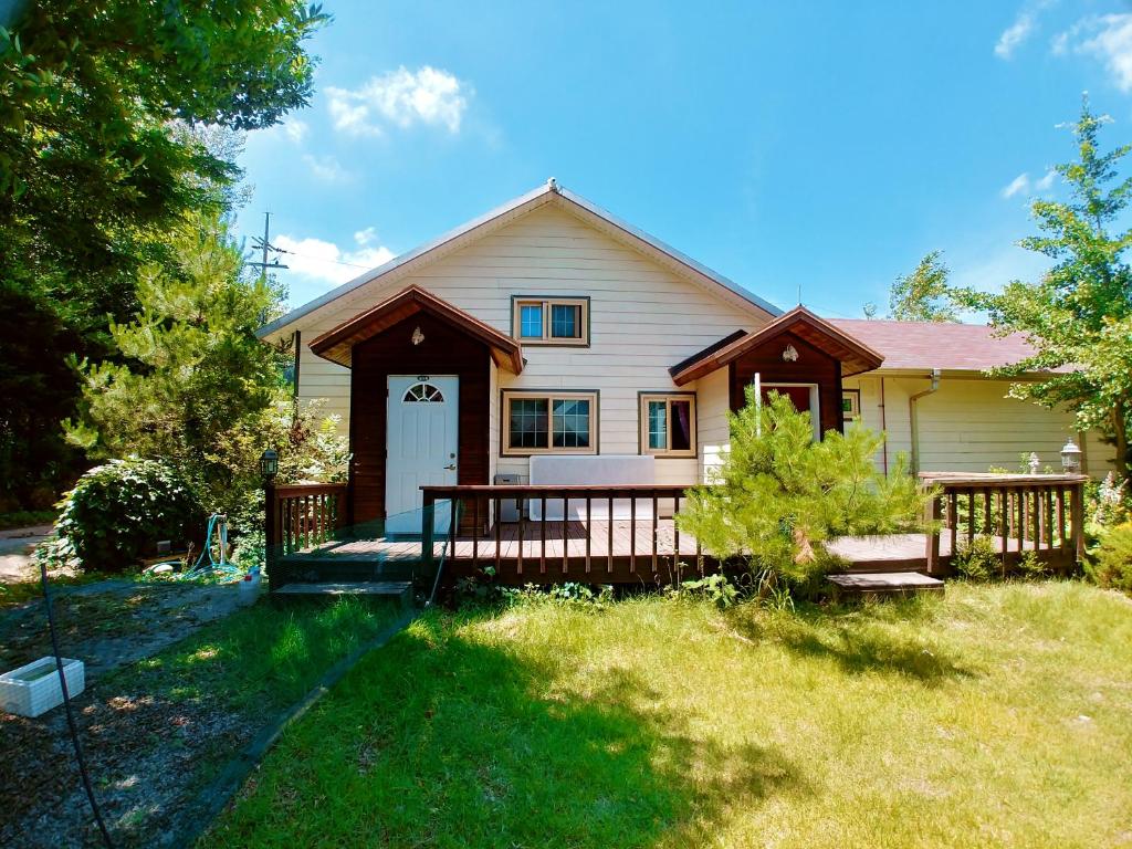 a house with a porch and a fence in the yard at Nadeuri Pension in Pyeongchang 