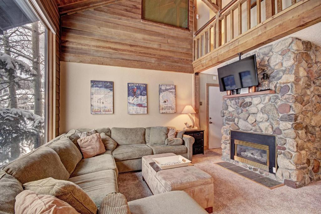 a living room with a couch and a stone fireplace at An203 Anaconda Condo in Copper Mountain