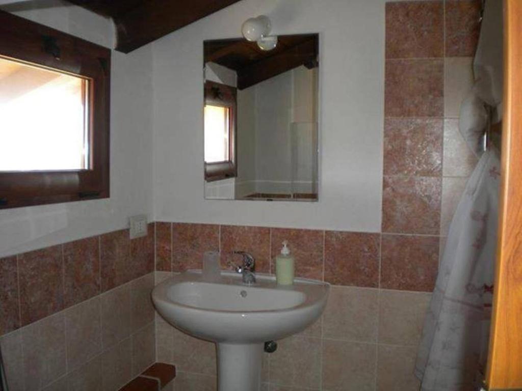 y baño con lavabo y espejo. en Affittacamere Luti, en Massama