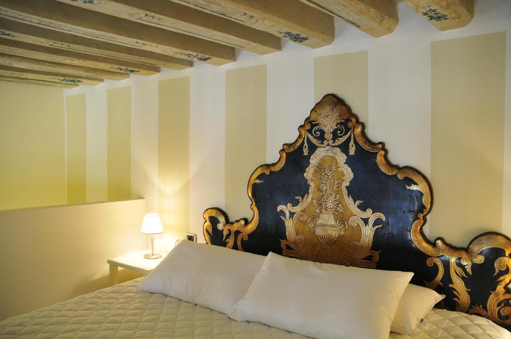 a bedroom with a bed with a blue and gold headboard at Ca' Mariele in Venice