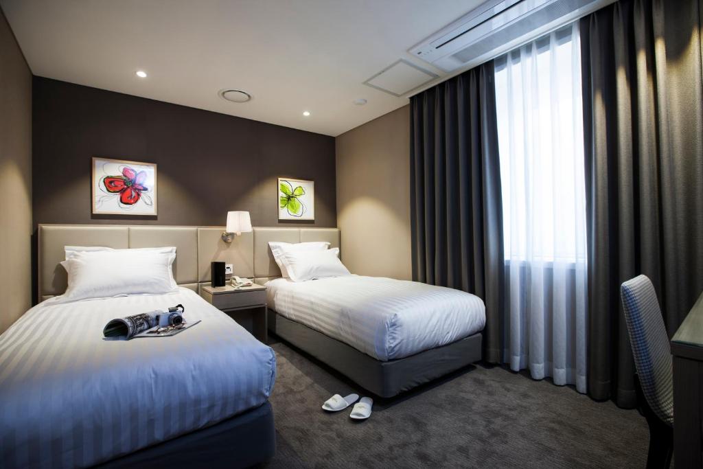 Postel nebo postele na pokoji v ubytování The Grand Hotel Myeongdong