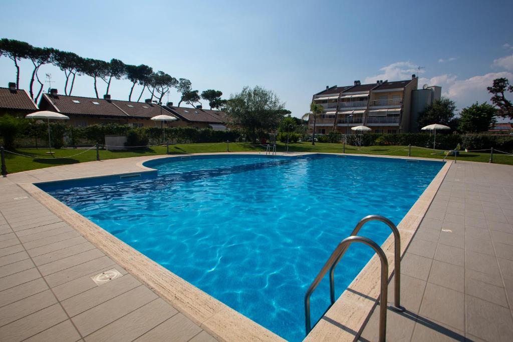 una grande piscina blu in un resort di Alloggio Parco di Plinio a Infernetto
