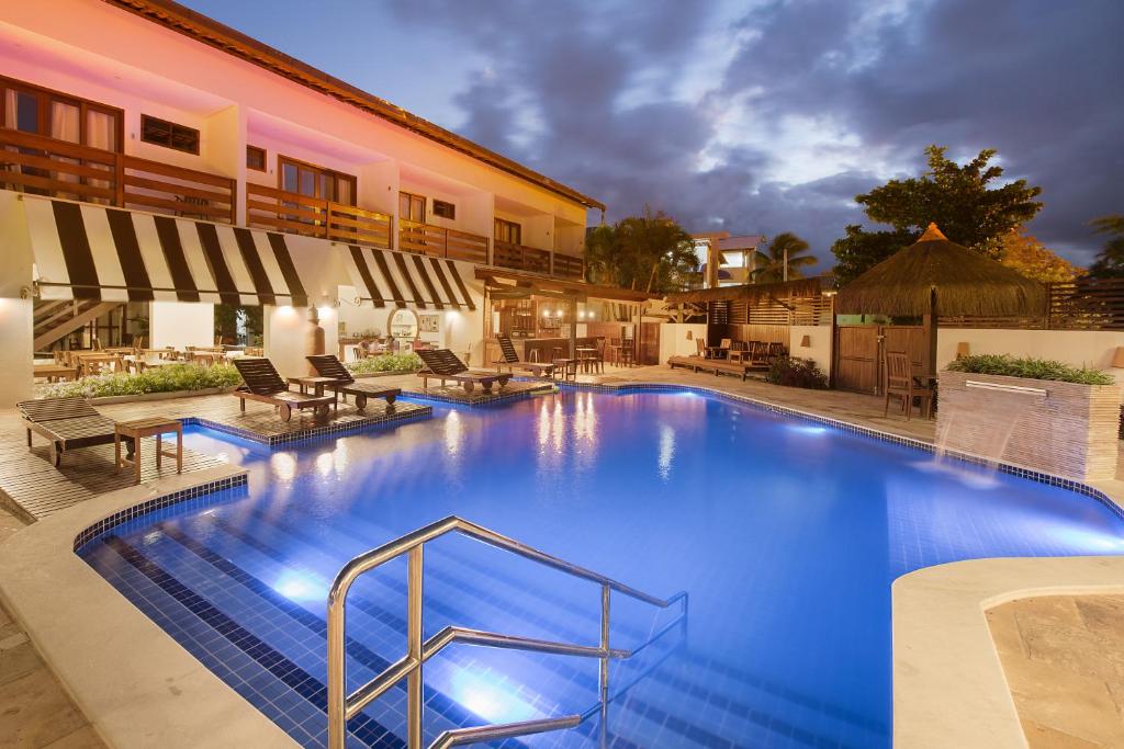 a large pool with blue water in a resort at Pousada Quatro Estações in Porto De Galinhas