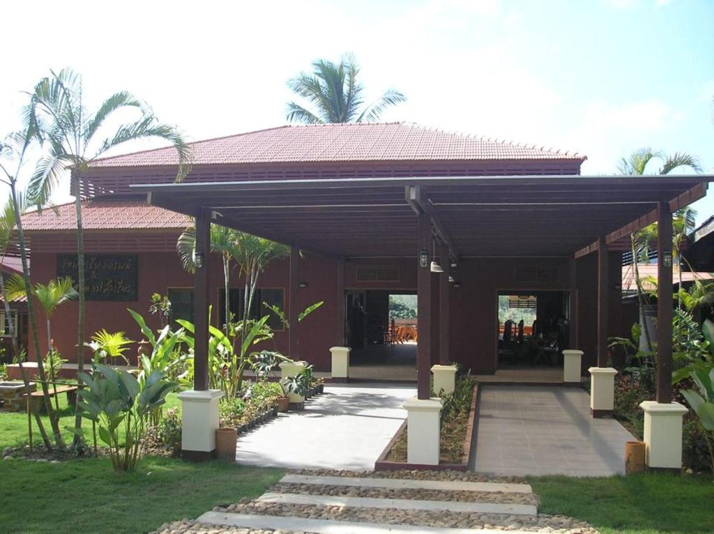 ein Haus mit einem überdachten Gang davor in der Unterkunft Tamarind Grand Resort Mae Sariang in Mae Sariang