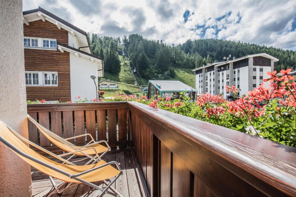 a couple of chairs sitting on a balcony with flowers at Albergo K2 in Madesimo