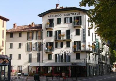 duży biały budynek po stronie ulicy w obiekcie Hotel Centrale w mieście San Pellegrino Terme