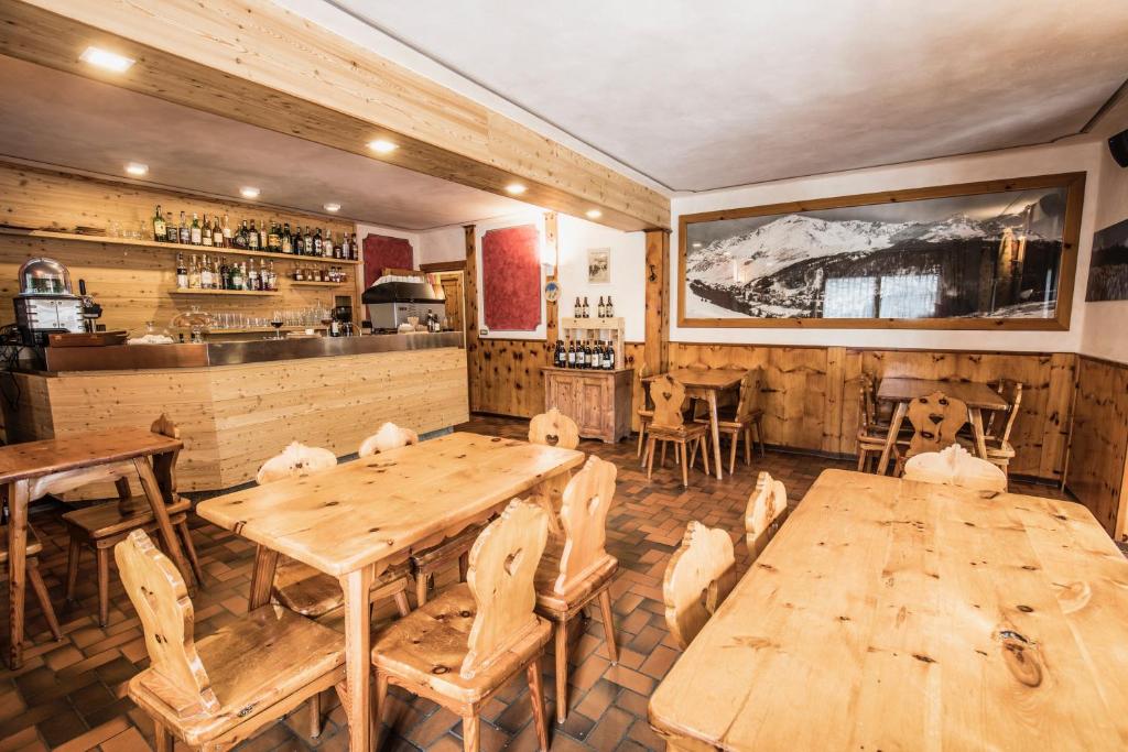 a restaurant with wooden tables and chairs and a bar at Albergo K2 in Madesimo