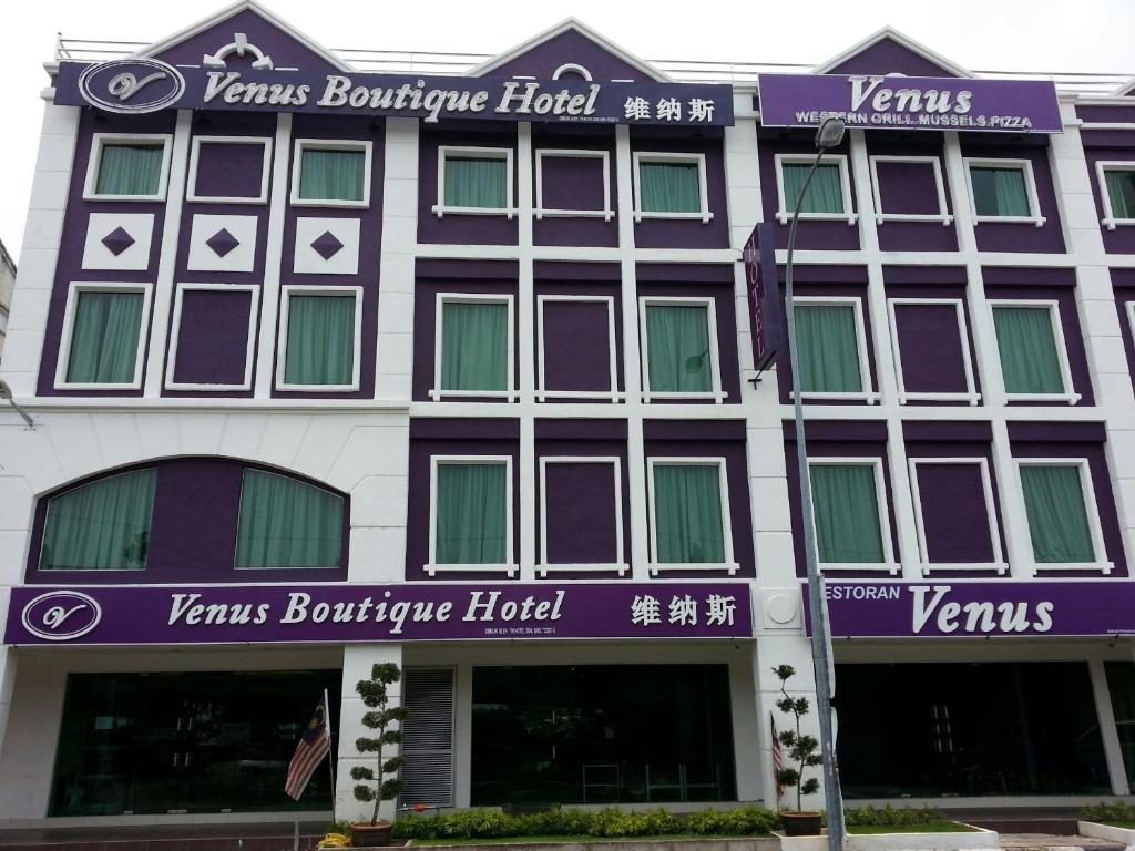 un edificio púrpura y blanco con un cartel en él en Venus Boutique Hotel, en Melaka