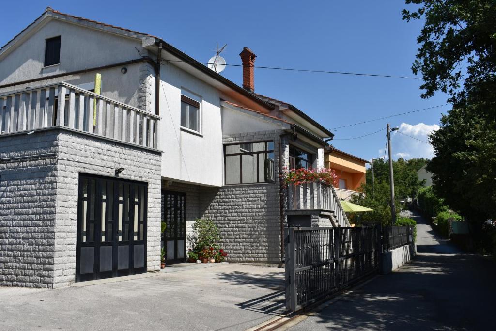 a white brick house with a black gate at Apartment Eni in Matulji