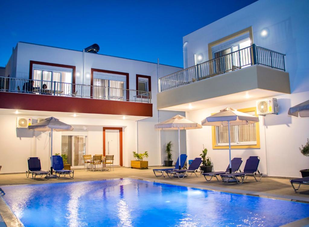 a villa with a swimming pool in front of a house at Gennadi Gardens exclusive apartments in Gennadi