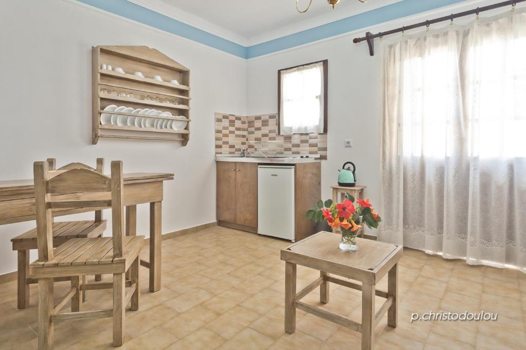 a living room with a table and chairs and a kitchen at Philoxenia Apartments in Karpathos