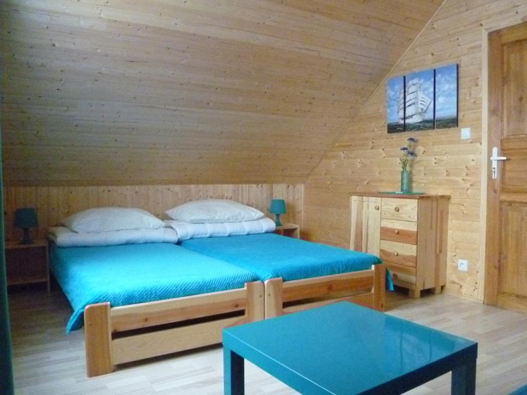um quarto com uma cama num quarto de madeira em Tęczowe Domki em Władysławowo