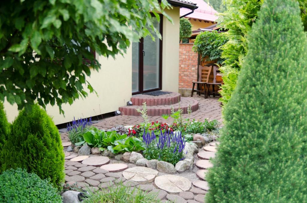 a garden with flowers and plants in front of a house at Domek Letniskowy Pucka in Mieroszyno