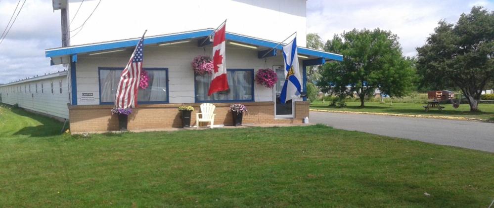 a building with three flags on the side of it at Berry's Motel in Truro