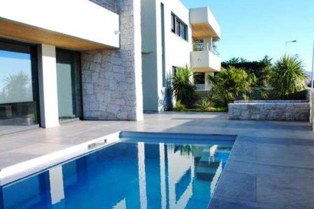 une maison avec une piscine en face d'une maison dans l'établissement Villa d'exception, piscine, vue mer, plage à 100M, à Ajaccio