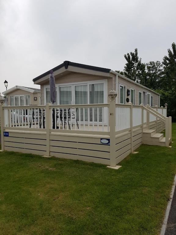 a large house with a white fence in the grass at Kent Getaways in Westgate-on-Sea