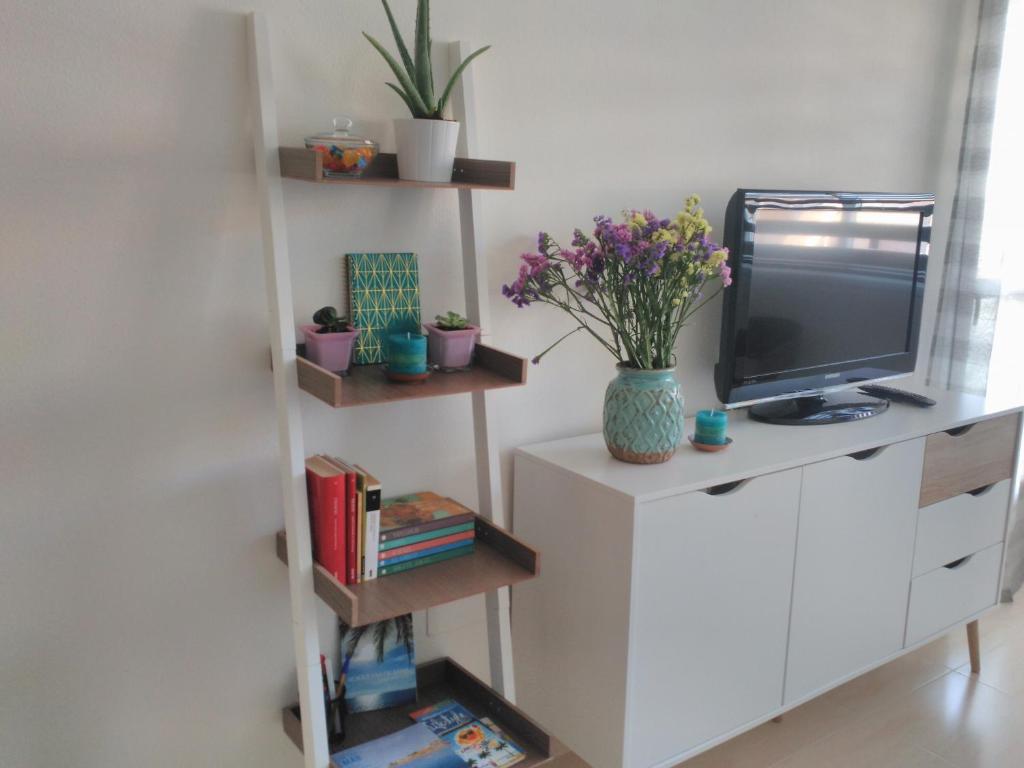 a living room with a tv on a white shelf at Airem 22 in Roquetas de Mar