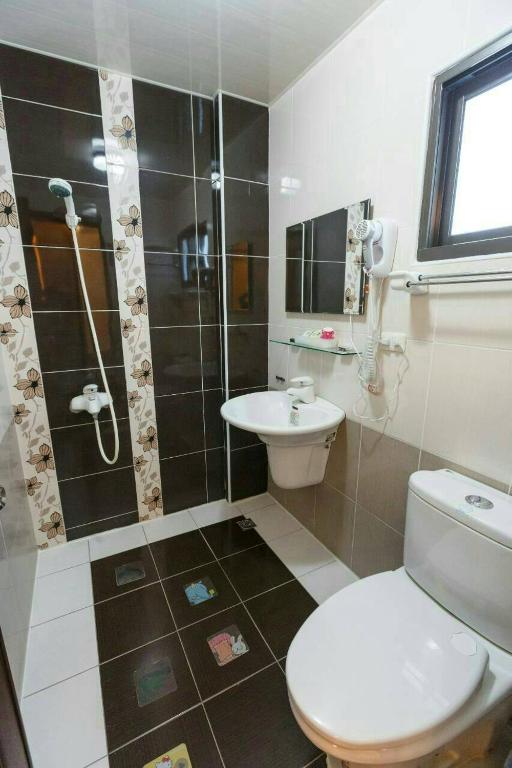 a bathroom with a toilet and a shower and a sink at Kenting Mulan Homestay in Hengchun South Gate