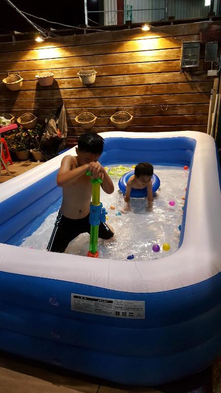 two young boys playing in a pool in a inflatable at Kenting Mulan Homestay in Hengchun South Gate