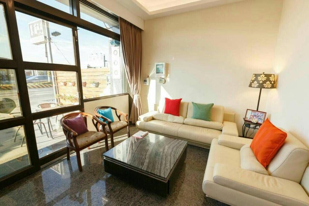 a living room with two couches and a table at Kenting Mulan Homestay in Hengchun South Gate