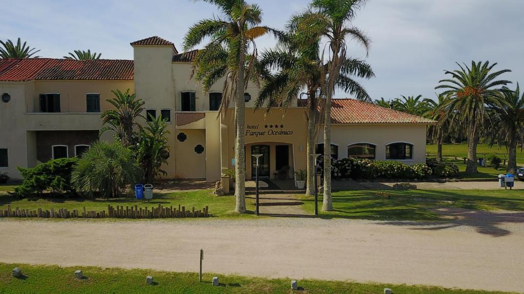 um edifício com palmeiras em frente em Hotel Parque Oceánico em La Coronilla