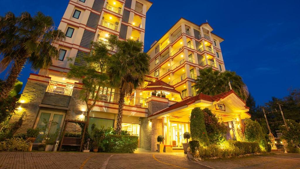 un gran edificio con luces encendidas por la noche en Kiang Haad Beach Hua Hin, en Hua Hin