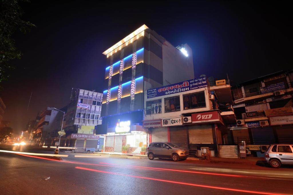 a building at night with cars parked in front of it at Hotel One Up in Ahmedabad