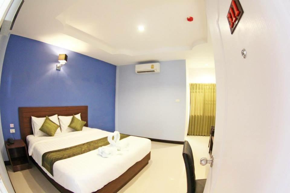 ein Schlafzimmer mit 2 Betten und einer blauen Wand in der Unterkunft BK Place Hotel in Bung Kan