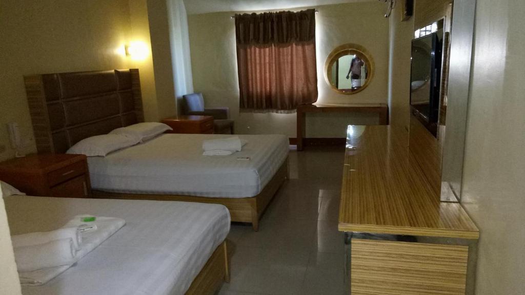 Postel nebo postele na pokoji v ubytování Jeamco Royal Hotel-Cotabato