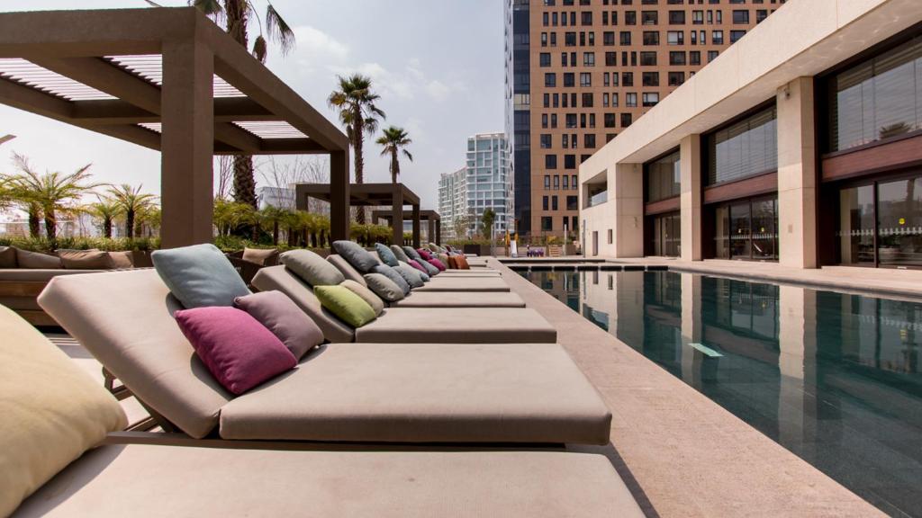 - une rangée de chaises longues à côté de la piscine dans l'établissement Miyana Luxury Studio, à Mexico