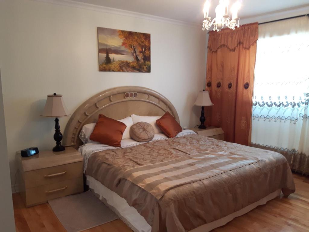 a bedroom with a large bed and a chandelier at Three bedroom holiday apartment in Longueuil