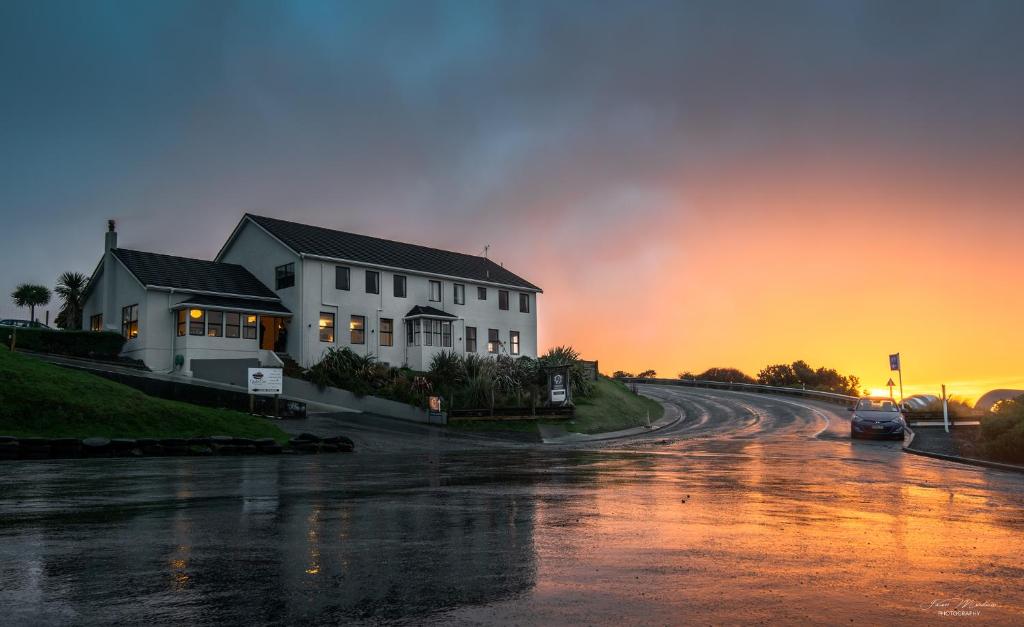 a house on a road with a sunset in the background at Lands End in Bluff