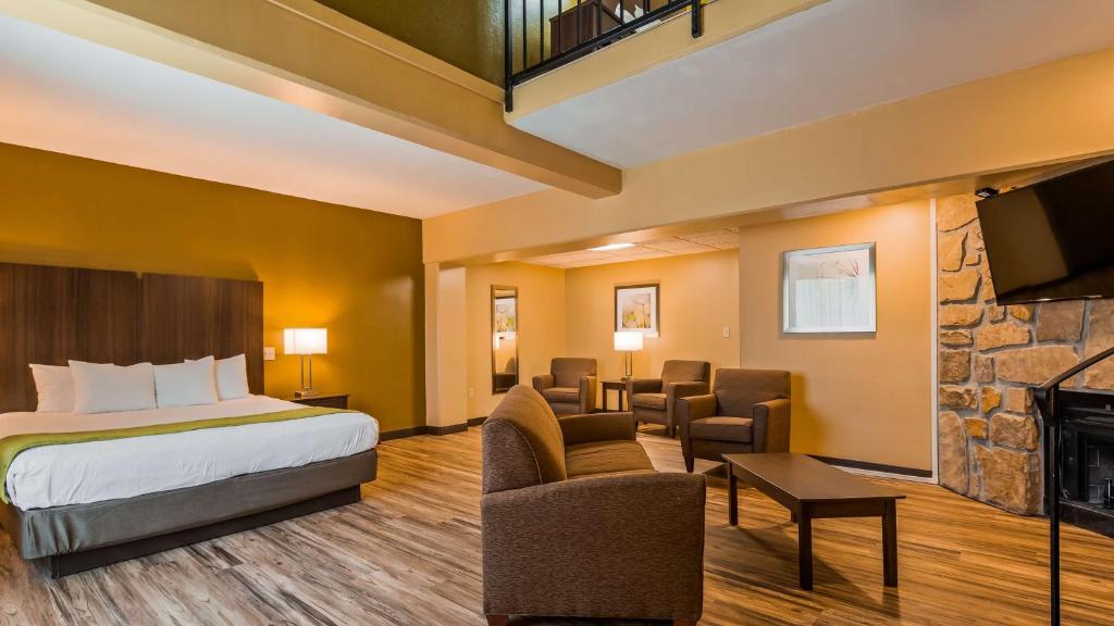 a hotel room with a bed and a fireplace at Best Western Plaza Inn in Pigeon Forge