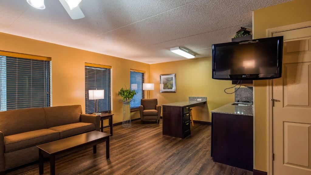 a living room with a couch and a flat screen tv at Best Western Plaza Inn in Pigeon Forge