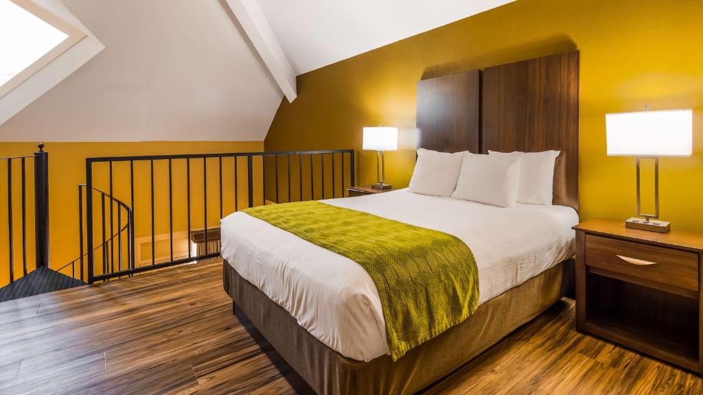 a bedroom with a large bed with yellow walls at Best Western Plaza Inn in Pigeon Forge