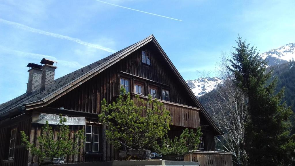 une maison en bois avec des montagnes en arrière-plan dans l'établissement Chalet St Jakob, à Sankt Anton am Arlberg